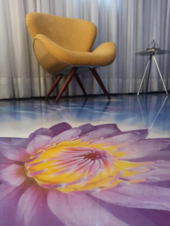 Poltrona amarela sobre o piso pintado com uma flor de lótus